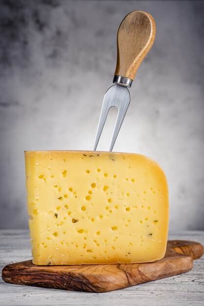 Piece of ammergauer beer cheese on a light wooden table