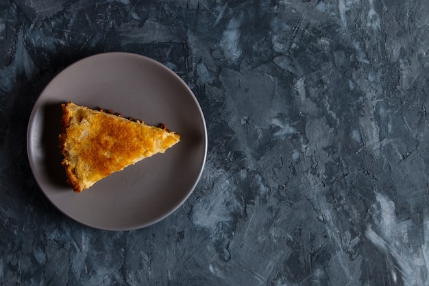 A piece of apple pie on a gray plate