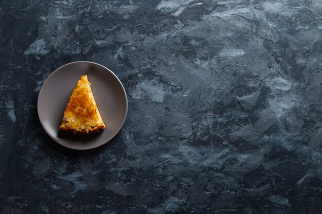 A piece of apple pie on a gray plate