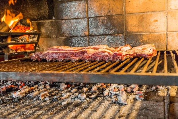 Piece of beef rib grilled next to the firewood with fire Concept of Argentinean asado