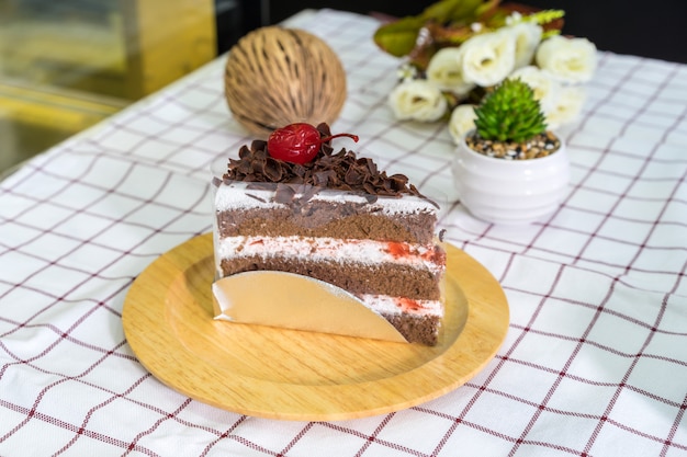 Piece of Black forest cake on wooden plate