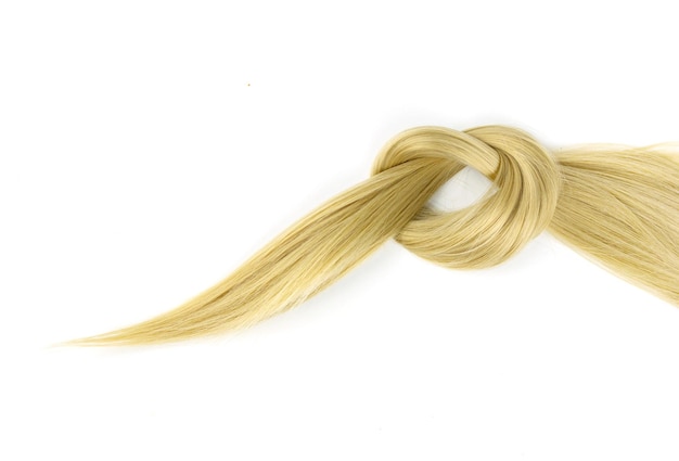 Piece of blonde hair lock tied in knot on white background Strand of blond silky hair on a white background