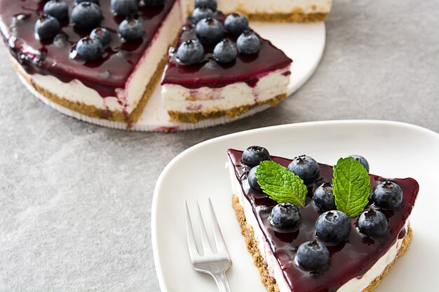 Piece of blueberry cheesecake on gray stone