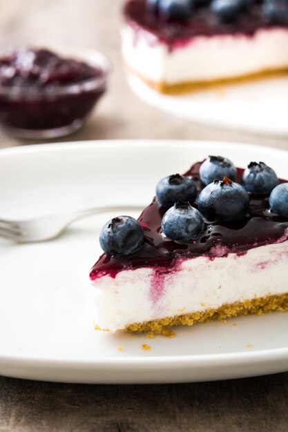 Piece of blueberry cheesecake on wood table