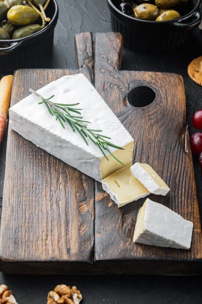 Piece of the brie cheese set, on black background