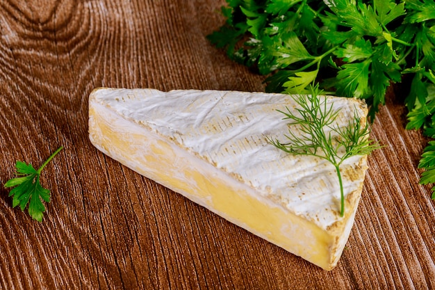 Piece of brie creme cheese on wooden surface