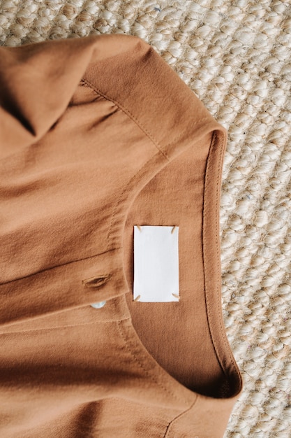 床のカーペットの上の茶色の服。ネック部分、上面図。
