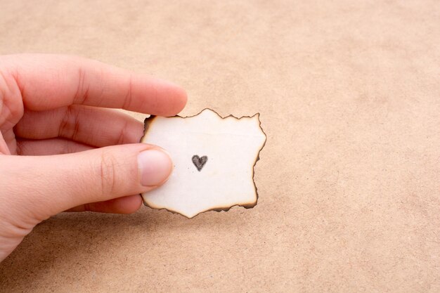 Piece of burnt paper with a heart on it