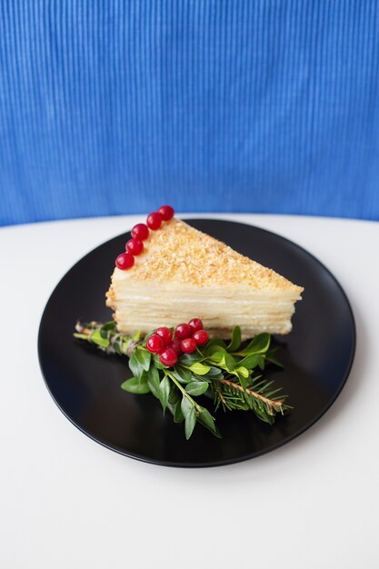 Piece of cake decorated with branches and berries