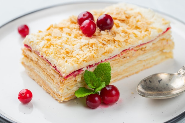 Piece of cake Napoleon on white plate Russian cuisine multi layered cake with pastry cream close up view