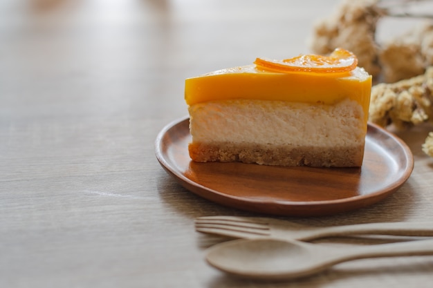 A piece of cake placed on a wooden plate.