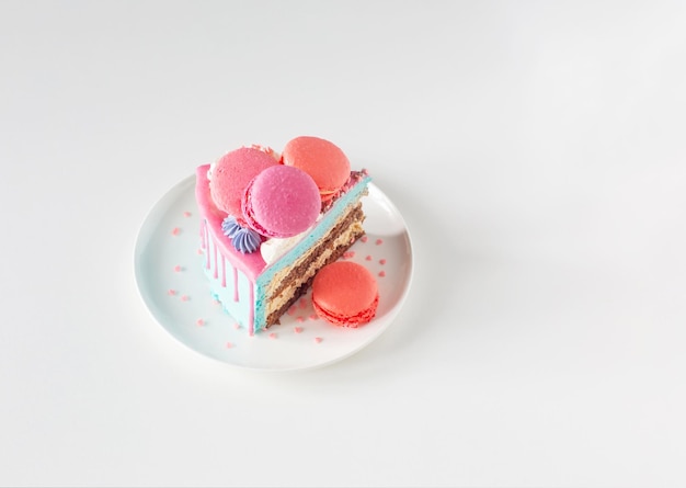 Piece of cake with pink and blue decor on white plate