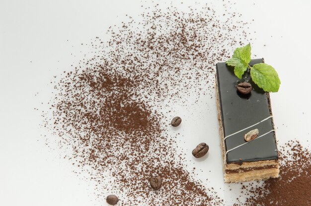 A piece of cake with sprinkled with powdered sugar on a white background