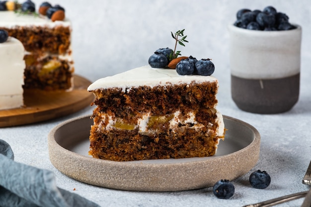 Piece of carrot cake with walnuts and blueberry on light background. Local food. Traditional american cake. Cake for thanksgiving day. Autumn cake.