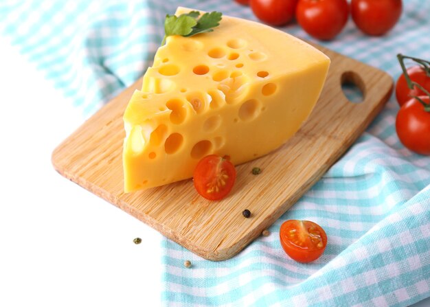 白で隔離の木の板の上のチーズとトマトの部分