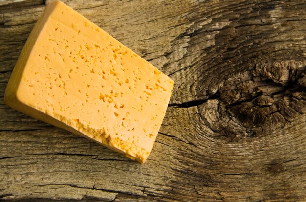 Piece of cheese on the wooden background