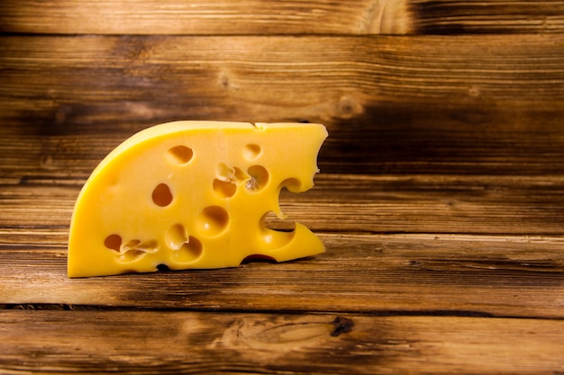 Piece of cheese on the wooden background