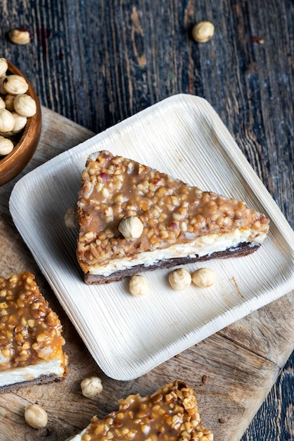 A piece of cheesecake cake with roasted peanuts in caramel