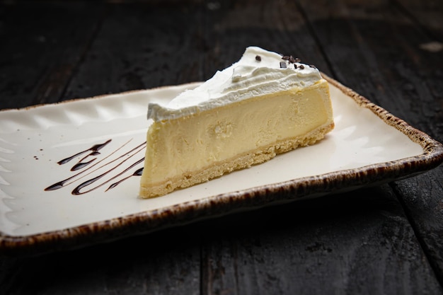 piece of cheesecake with cream and chocolate on a white plate