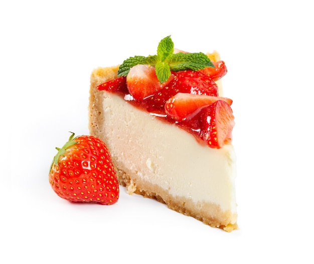 Piece of cheesecake with fresh strawberries and mint isolated on white background