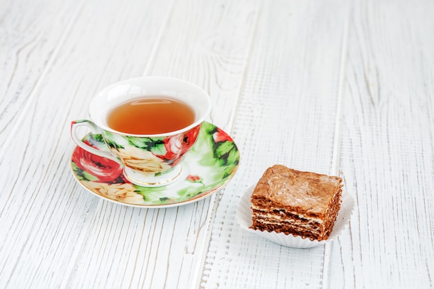 The piece of chocolate cake and a cup of tea. 