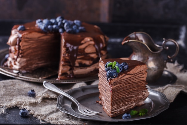 Кусок шоколадного торта из шоколадных блинов с глазурью