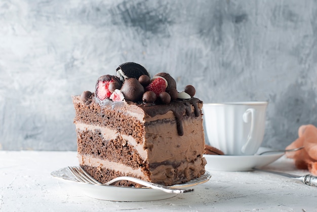 Piece of chocolate cake on a plate and a cup of coffee