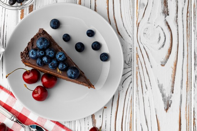 Pezzo di torta al cioccolato servito con frutti di bosco freschi