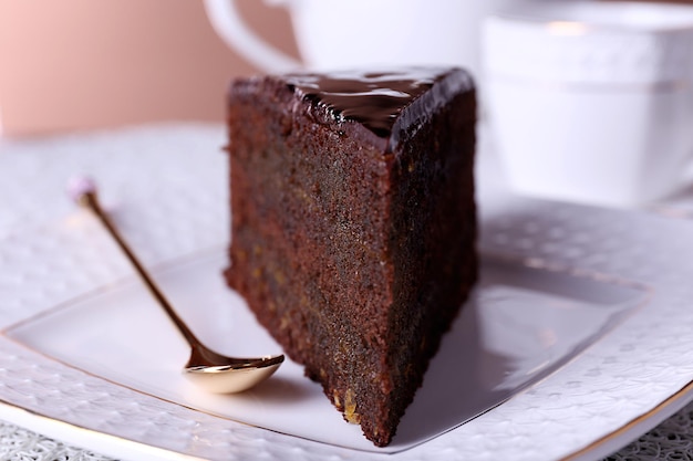 Piece of chocolate cake on white plate closeup