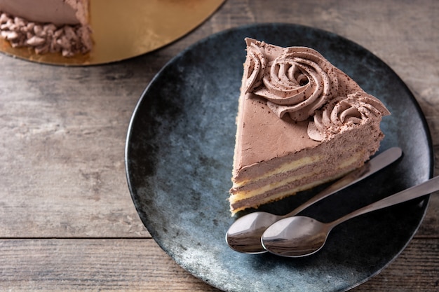 Piece of chocolate truffle cake on rustic wooden table