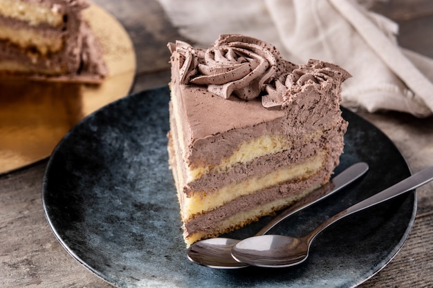 Piece of chocolate truffle cake on rustic wooden table