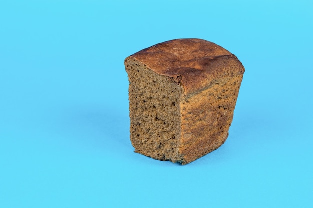 Un pezzo di pane scuro su sfondo blu