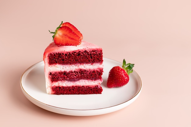 Piece of delicious red velvet cake decorated with fresh strawberries