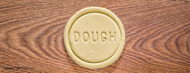 A piece of dough on an oak wood cutting board