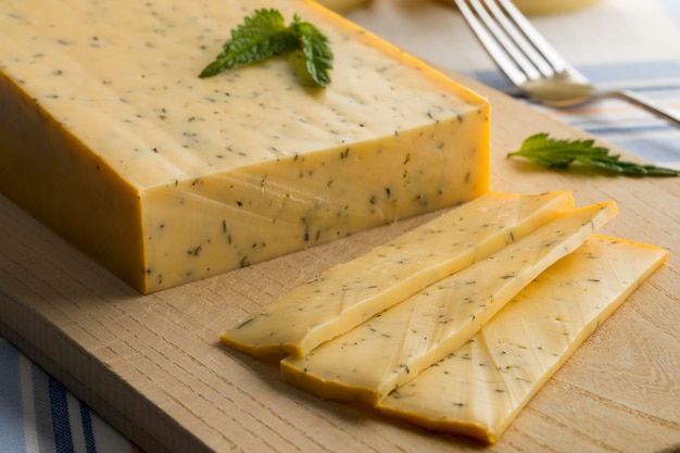 Piece of Dutch Gouda nettle cheese and slices