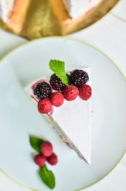 Piece of fresh biscuit yoghurt white yoghurt cake with fresh raspberries and blackberries