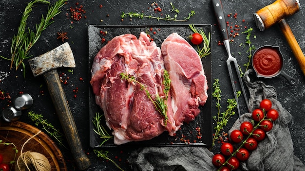 Pezzo di maiale crudo fresco dal collo con ingredienti e spezie su uno sfondo di cucina carne vista dall'alto stile rustico