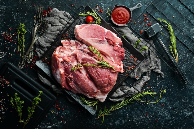 Piece of fresh raw pork from the neck with ingredients and spices on a kitchen background Meat Top view Rustic style