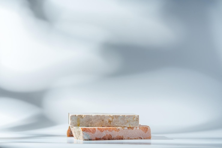 Photo piece of granite stone on white background with shadows