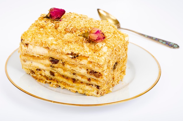 Piece of homemade puff pastry cake with cream on white plate. Studio Photo.