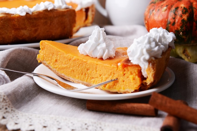 Piece of homemade pumpkin pie on plate on wooden background