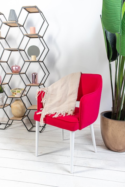 предмет интерьера красное кресло большой цветок в горке и стеллаж или полка с декором