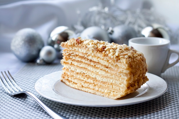 Piece of layer cake on a plate with Christmas balls