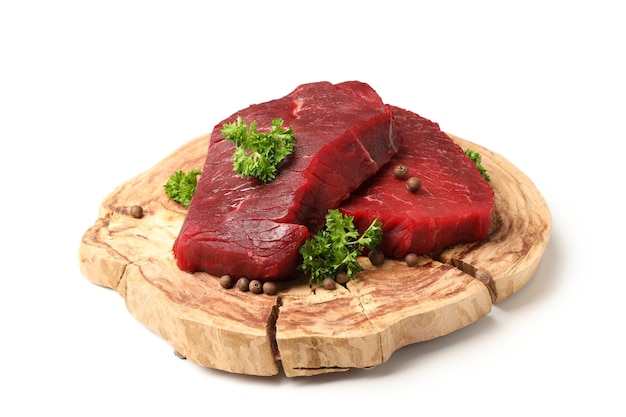 Piece of log with raw beef steaks isolated on white background