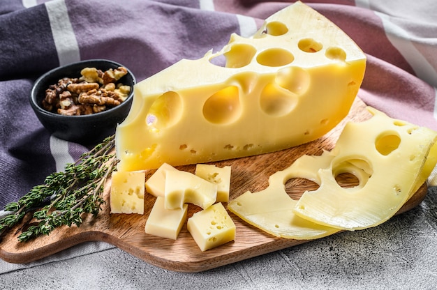 Piece of Maasdam cheese with large holes