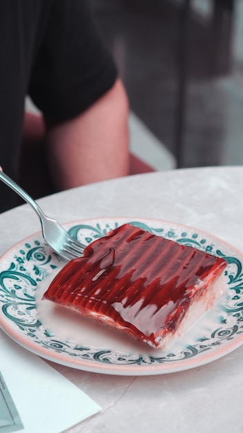 Foto un pezzo di carne viene tenuto su un piatto verde con una forchetta