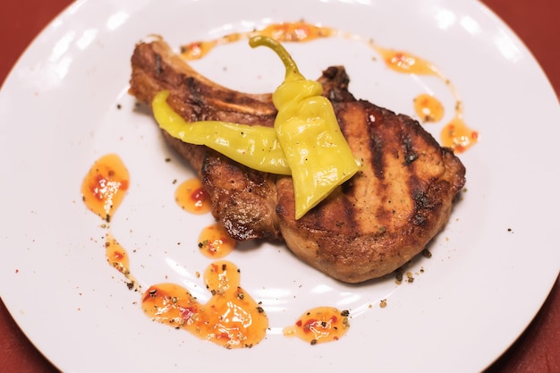 Piece of meat with pepper on a white plate