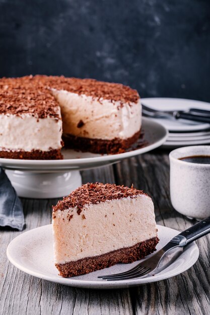 木製の素朴な背景のプレートにノバケチョコレートチーズケーキの一部