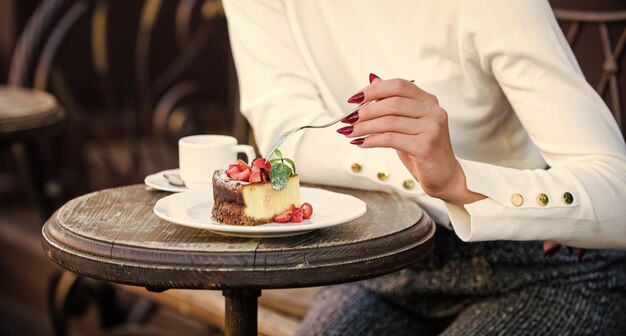 写真 赤いベリーのケーキグルメのレシピ食べ物白い皿のケーキスライスクリームでケーキ美味しいデザート食欲コンセプトデザートケーキコーヒーと女性の手とフォークのカップクローズアップ