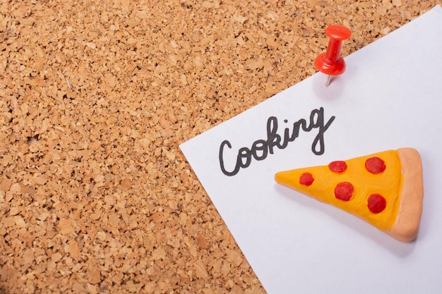 Фото Кусок пиццы икона и кулинарное слово на белой бумаге